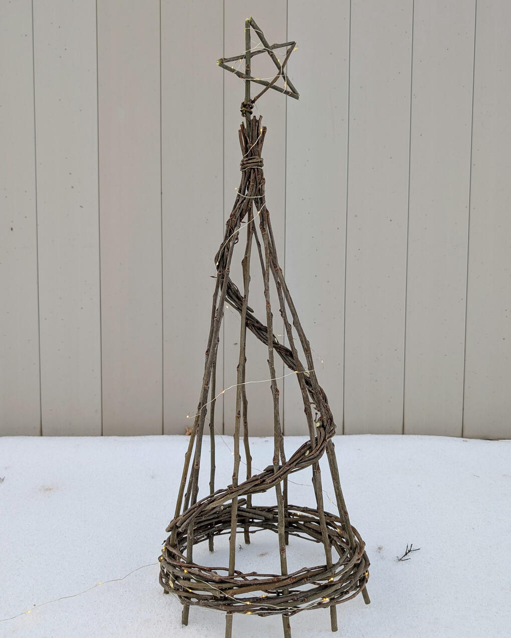 Spiral Porch Tree Willow spiral tree with lights and star on top, in the snow.
